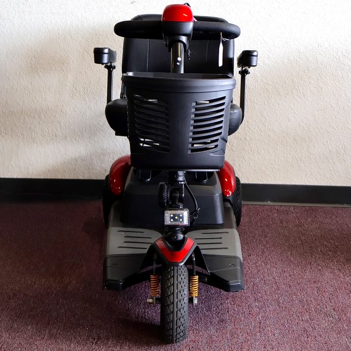 Pre-owned red Golden Buzzaround EX 3-wheel mobility scooter, photographed at the Mobility America showroom in Lakeland