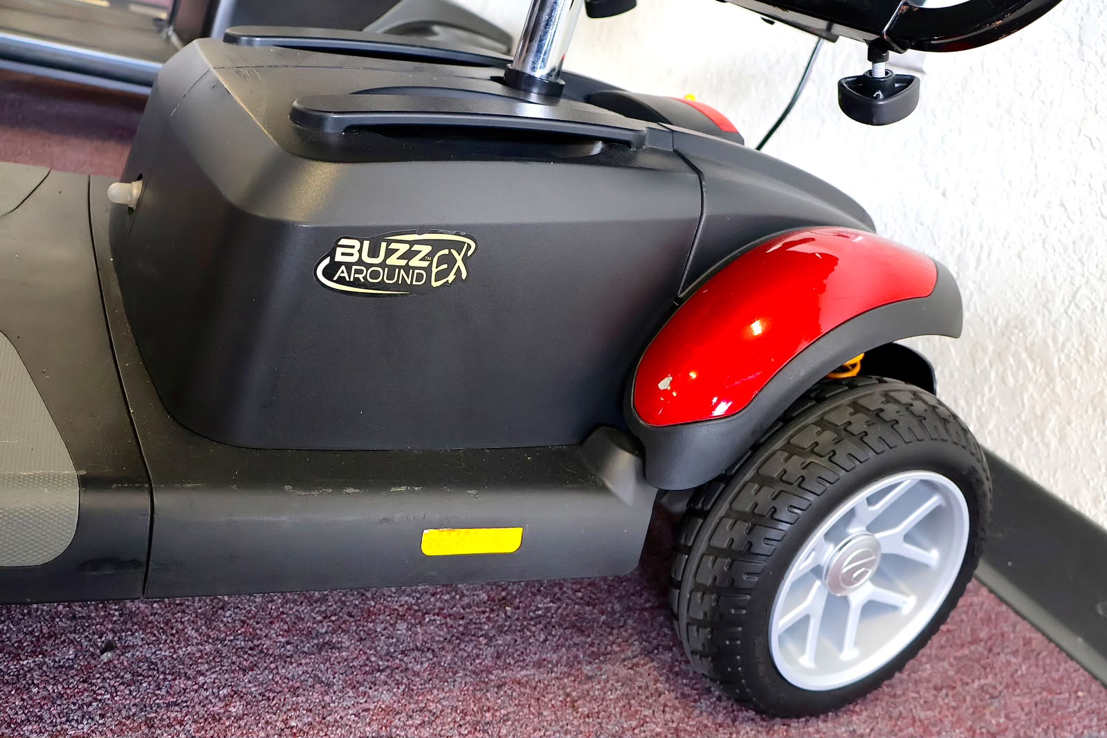 Pre-owned red Golden Buzzaround EX 3-wheel mobility scooter, photographed at the Mobility America showroom in Lakeland