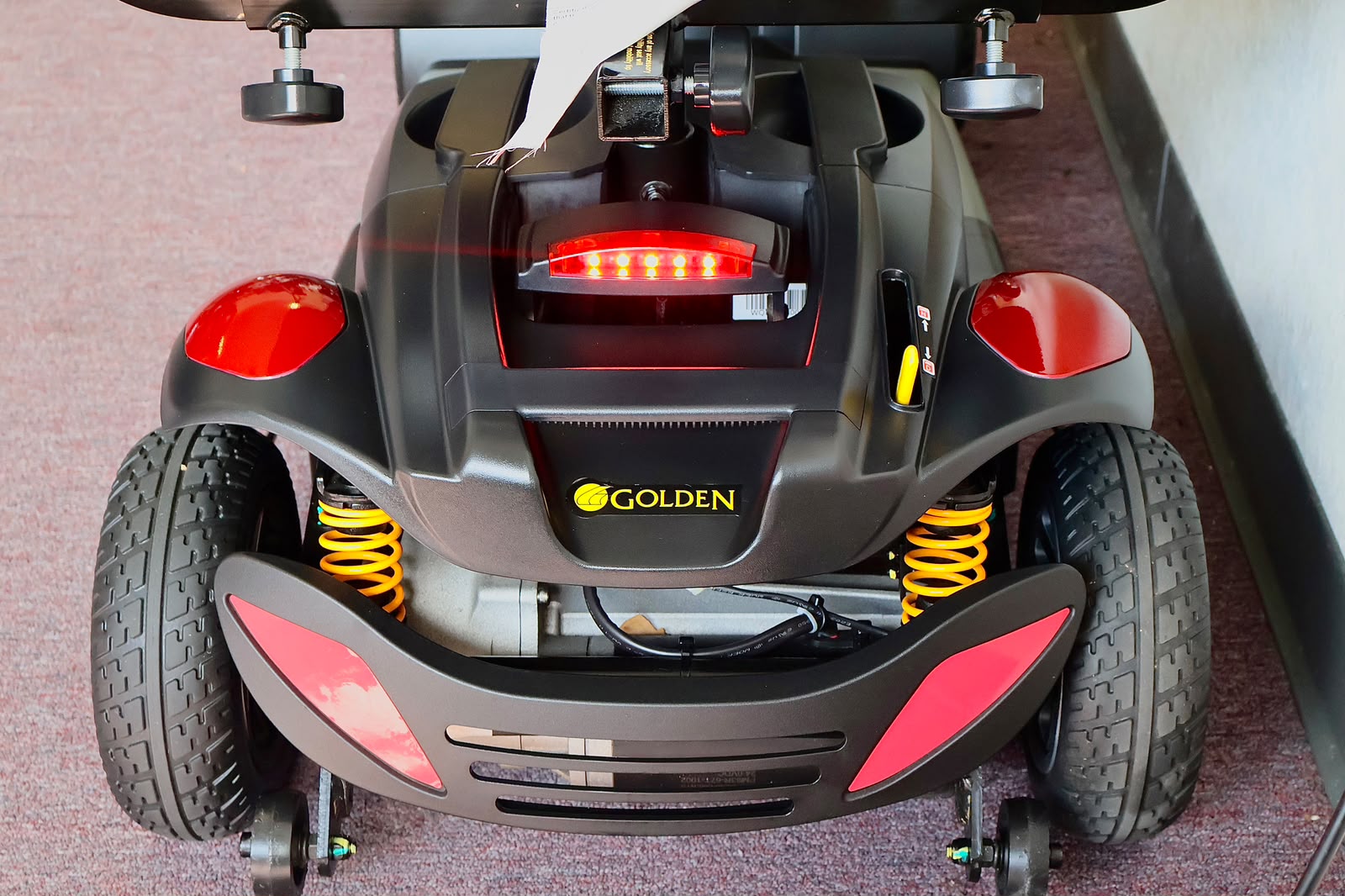 Pre-owned red Golden Buzzaround EX 4-wheel mobility scooter, photographed at the Mobility America showroom in Lakeland