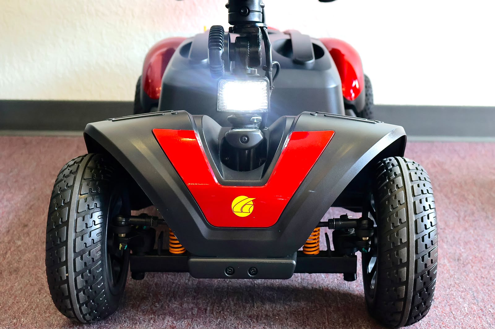 Pre-owned red Golden Buzzaround EX 4-wheel mobility scooter, photographed at the Mobility America showroom in Lakeland