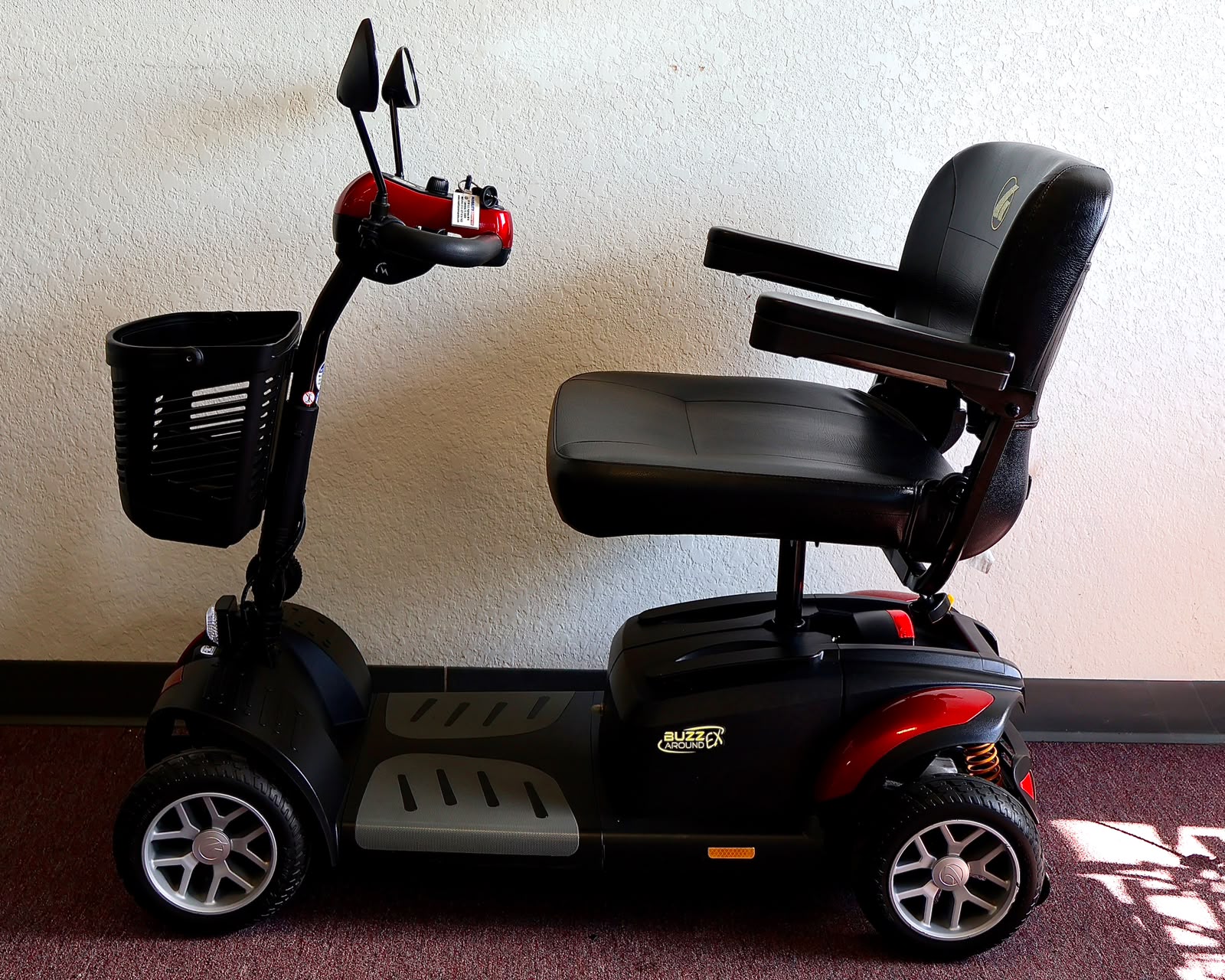Pre-owned red Golden Buzzaround EX 4-wheel mobility scooter, photographed at the Mobility America showroom in Lakeland