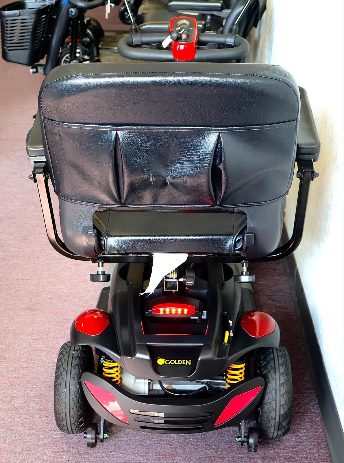 Pre-owned red Golden Buzzaround EX 4-wheel mobility scooter, photographed at the Mobility America showroom in Lakeland
