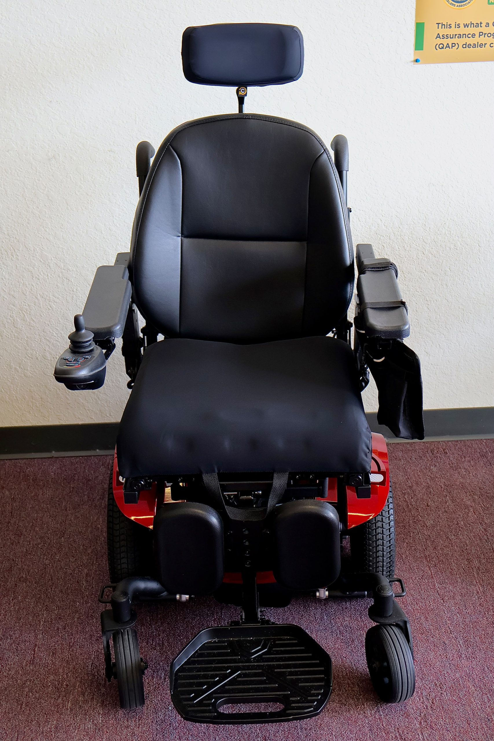 Pre-owned red Merits Vision Ultra rehab power wheelchair with manual attendant control, photographed at the Mobility America showroom in Lakeland