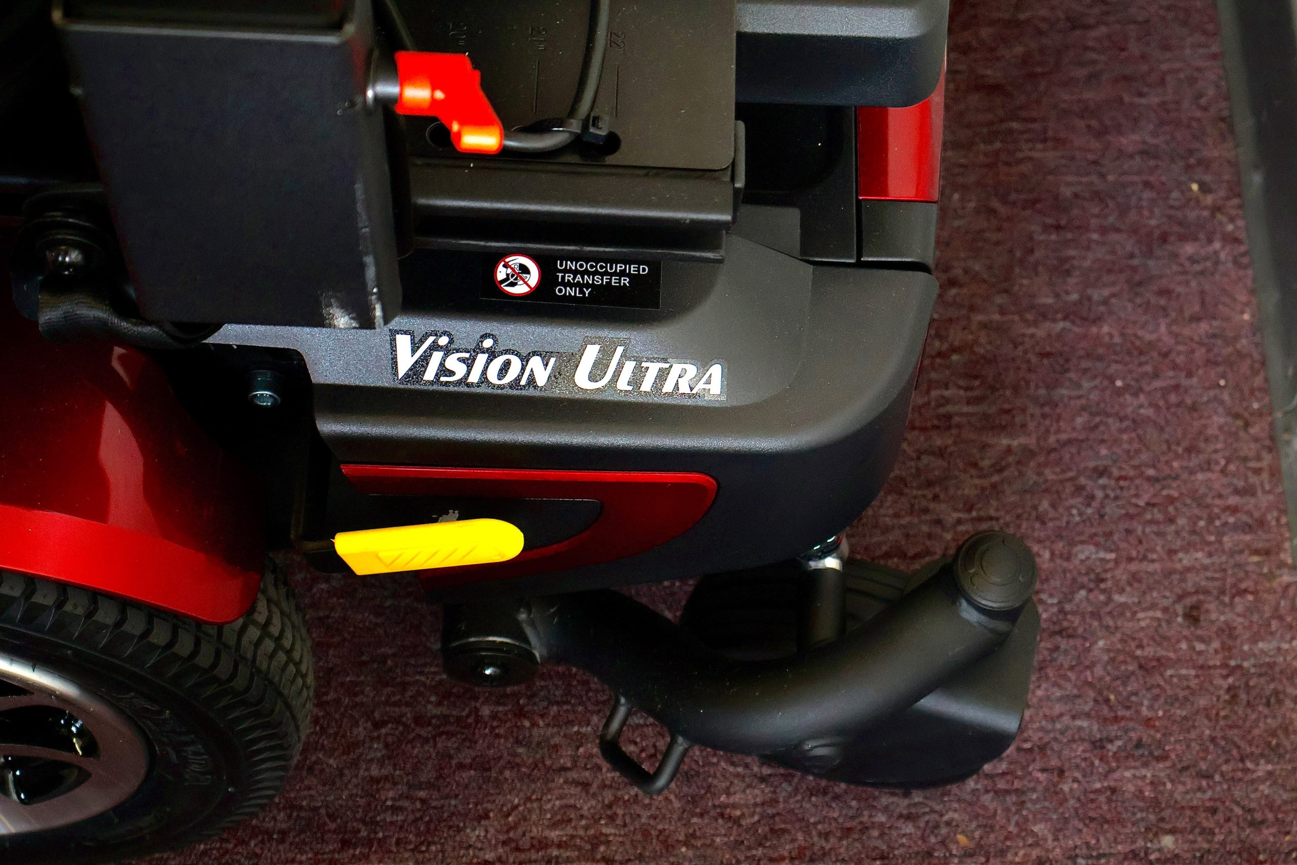 Pre-owned red Merits Vision Ultra rehab power wheelchair with manual attendant control, photographed at the Mobility America showroom in Lakeland