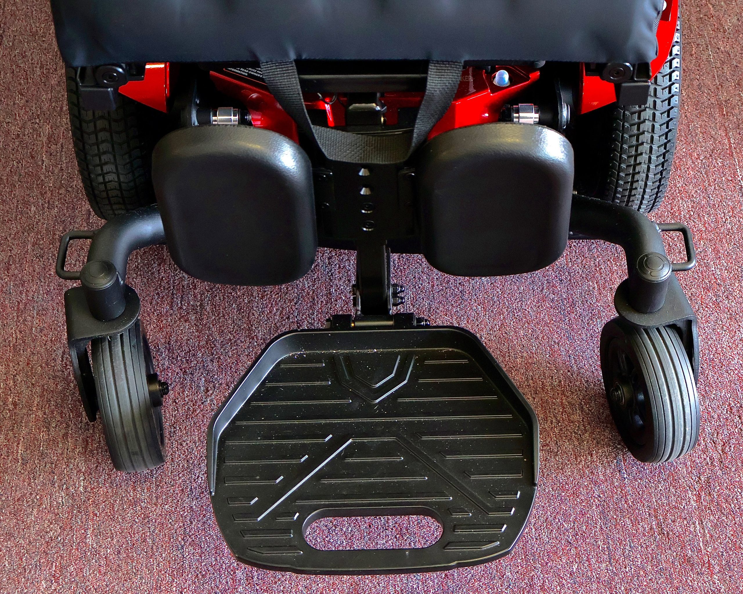 Pre-owned red Merits Vision Ultra rehab power wheelchair with manual attendant control, photographed at the Mobility America showroom in Lakeland