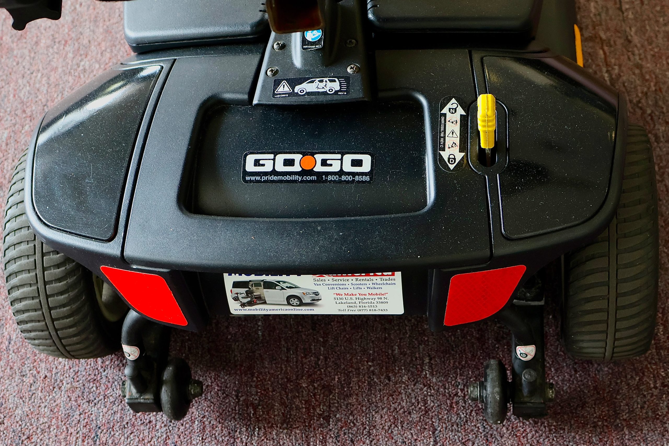 Pre-owned black Pride Go-Go Elite Traveller 3-wheel mobility scooter, photographed at the Mobility America showroom in Lakeland