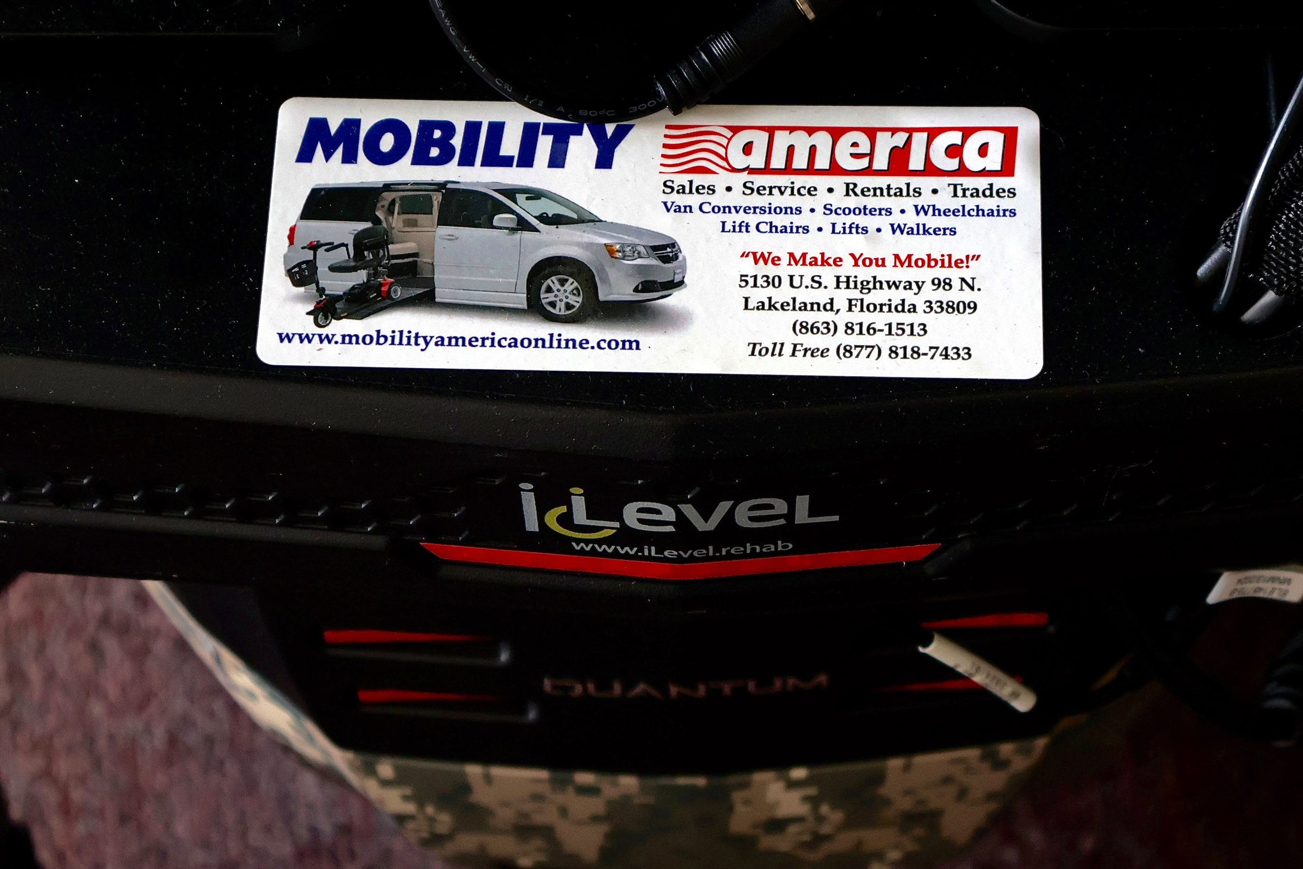 Pre-owned Quantum iLevel rehab power wheelchair in digital camo, photographed at the Mobility America showroom in Lakeland