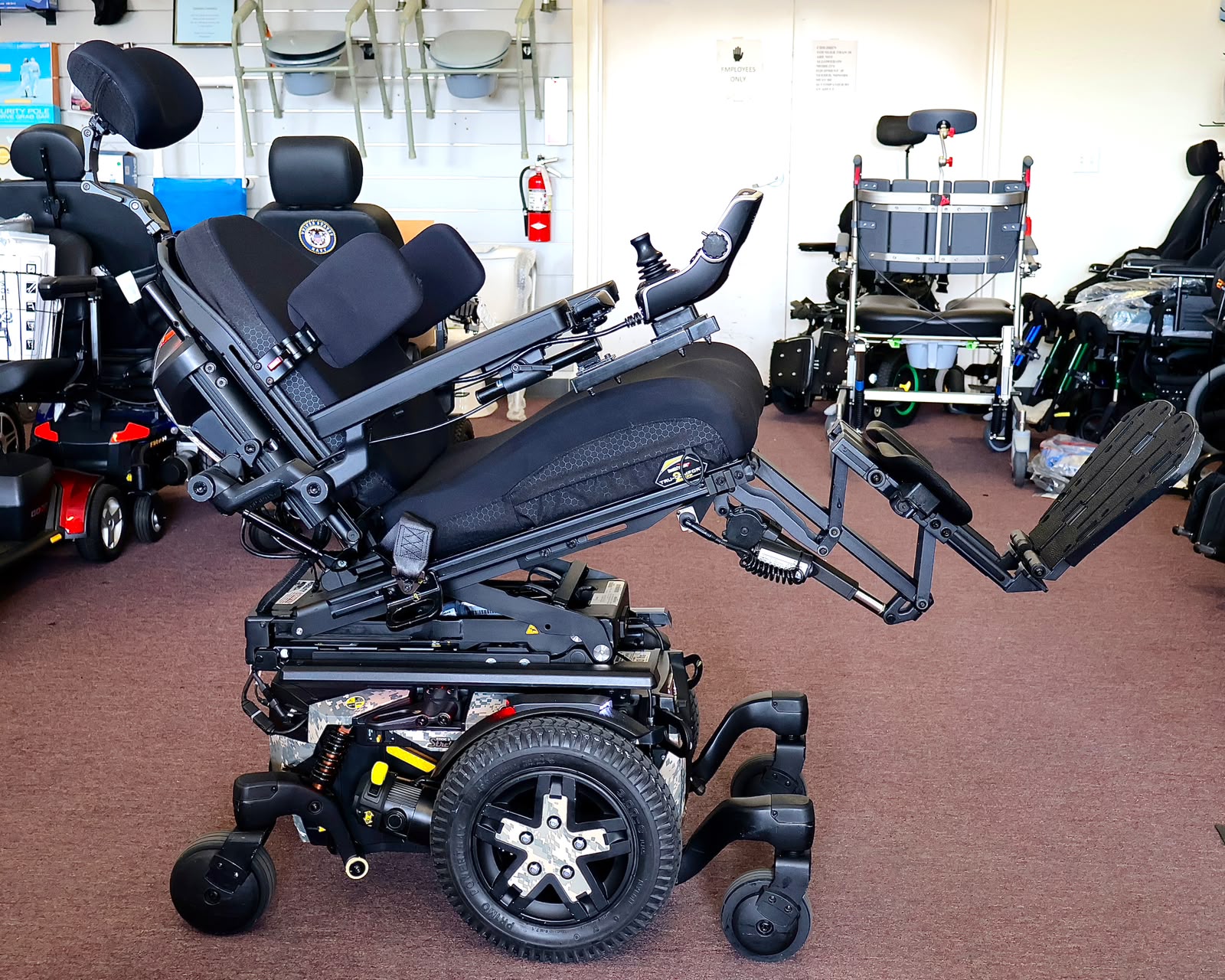Pre-owned Quantum iLevel rehab power wheelchair in digital camo, photographed at the Mobility America showroom in Lakeland
