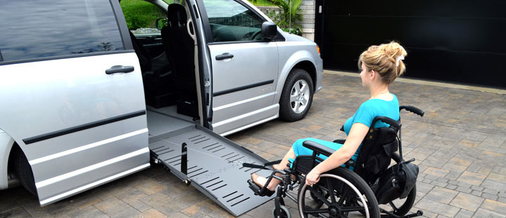 A powered hook system pulling a wheelchair up the ramp of a lowered-floor minivan