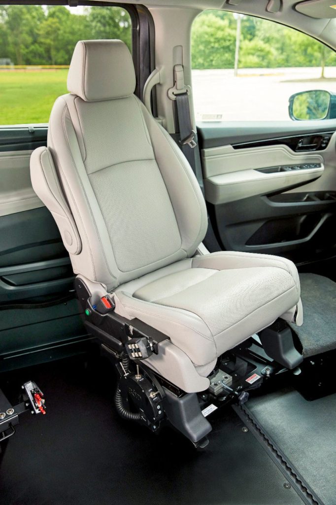 A vehicle front seat turned inward on a powered transfer base inside a lowered-floor van