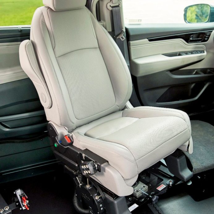 A vehicle front seat turned inward on a powered transfer base inside a lowered-floor van