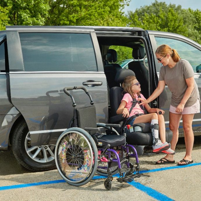 A powered transfer seat rotated out of a vehicle door frame and lowered ready for transfer