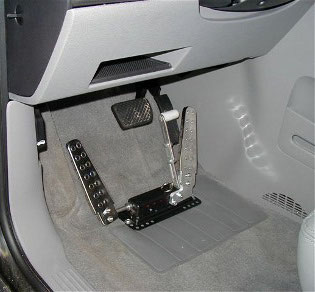 A left-foot accelerator pedal with pedal guard fitted to the left of the brake